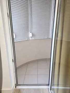 Pogled kroz balkonska vrata na zastakljenu terasu sa keramičkim pločicama. - image 6