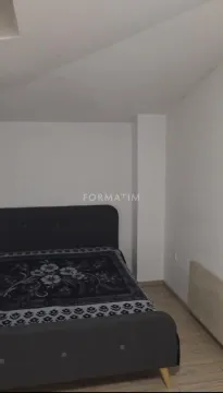 Spavaća soba sa bračnim krevetom i belim zidovima. - image 8