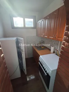 Manja kuhinja sa drvenim elementima, šporetom i frižiderom. - image 4