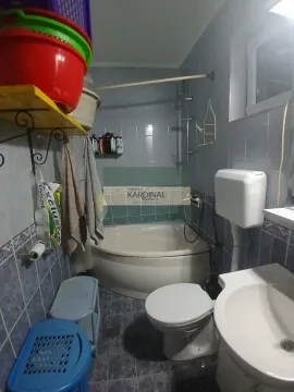 Manje kupatilo sa kadom, toaletom i umivaonikom obloženo pločicama. - image 7