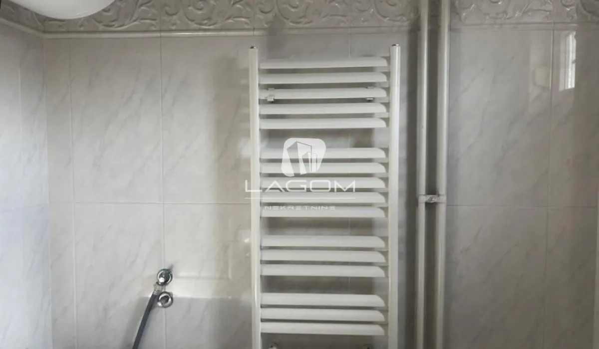 White towel radiator in a tiled bathroom.