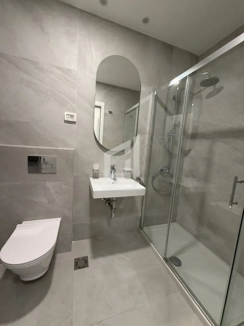 Moderno opremljeno kupatilo sa tuš kabinom, umivaonikom i wc šoljom.