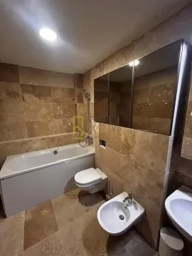 Potpuno opremljeno kupatilo sa kadom, toaletom, bideom i umivaonikom u braon keramičkim pločicama. - image 17