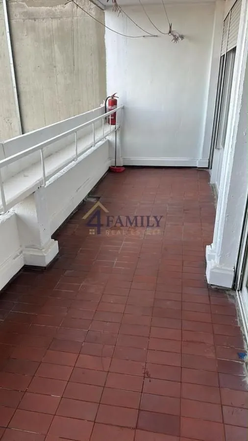 Dugačka terasa sa popločanim podom i ogradom.
