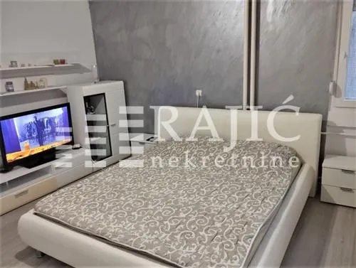 Bedroom with a double bed, television, and dresser.