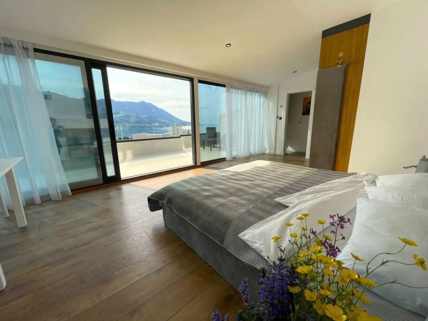 Spacious bedroom with large glass surfaces and sea view.