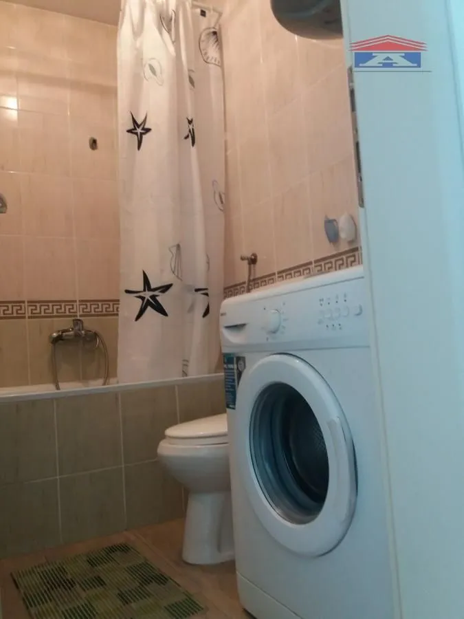 Manje kupatilo opremljeno kadom, veš mašinom i toaletom.