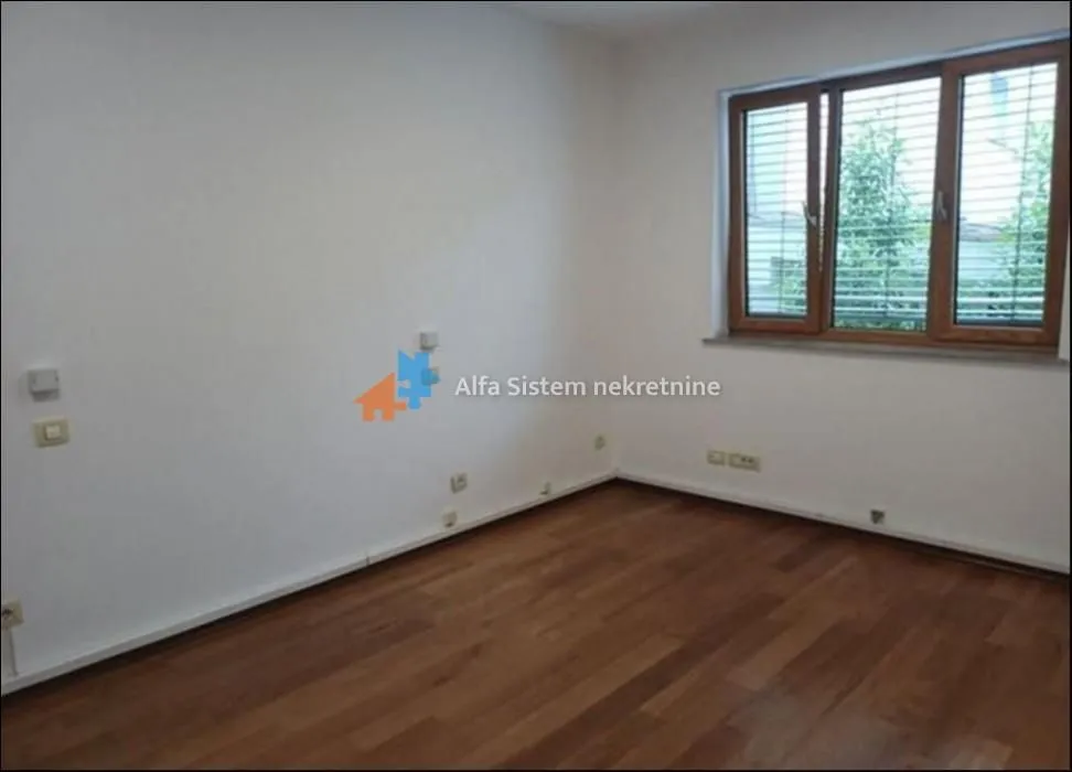 Empty room with wooden flooring and a window.