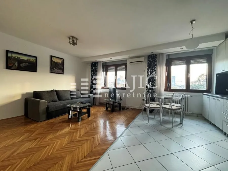 Living room with dining area and parquet flooring.