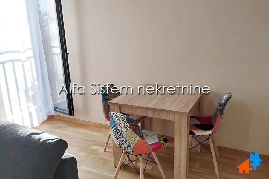 Small dining table with colorful chairs in the living room.