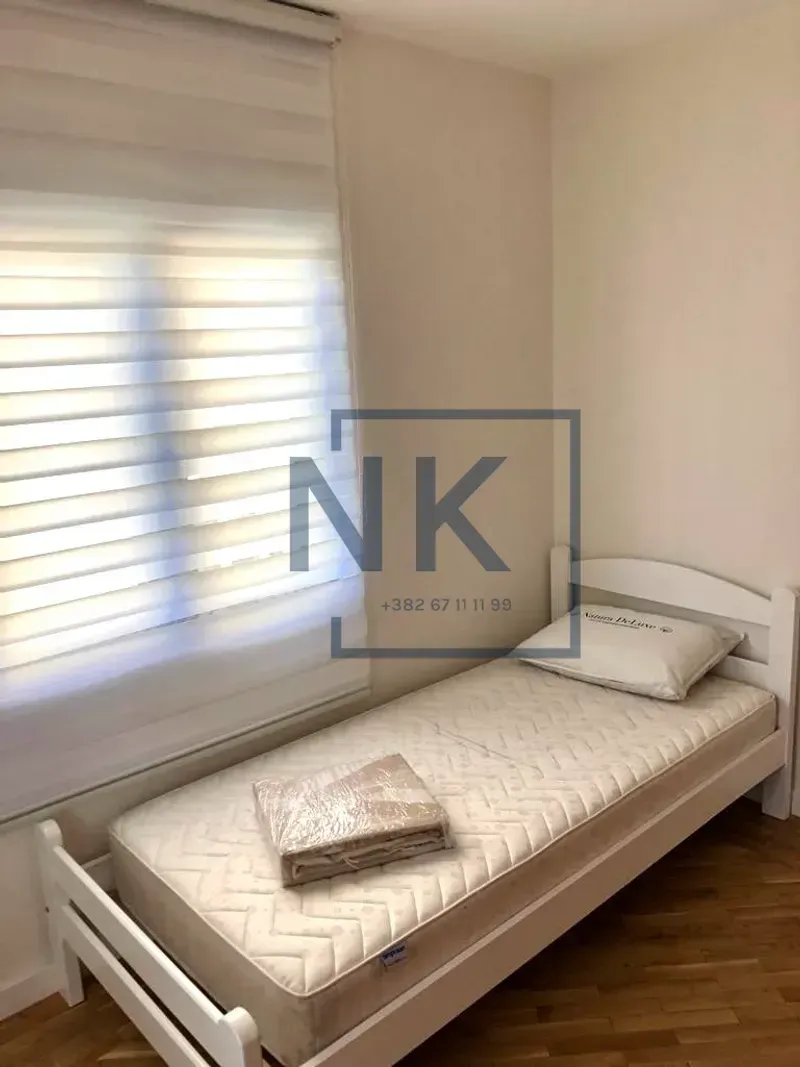 Smaller bedroom with a single bed and a window with blinds.