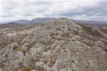 Krševit planinski teren pod oblačnim nebom. - image 2