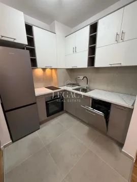 Modern kitchen with white and grey cabinetry, refrigerator, and built-in appliances. - image 16