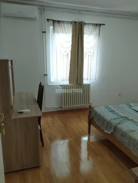 Nameštena spavaća soba sa krevetom, radnim stolom i prozorom. - image 4