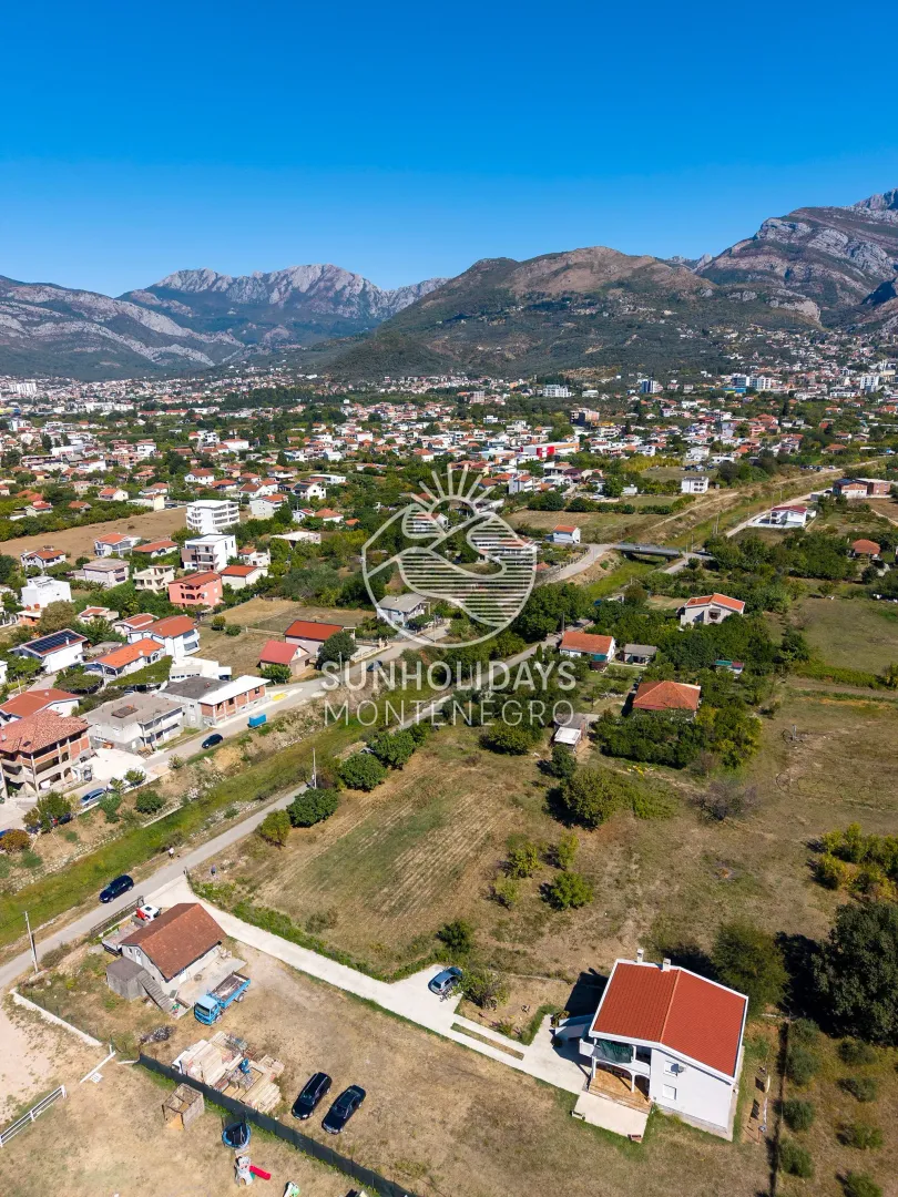 Pogled iz vazduha na naselje i okolne planine.