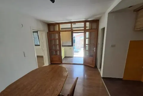 Dnevna soba sa trpezarijskim stolom i drvenim vratima koja vode na terasu. - image 12