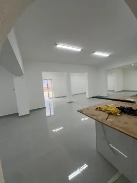 Empty commercial space with tiled floors and a workbench in the foreground. - image 6