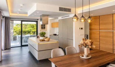 Modern kitchen with an island and dining area, with access to the terrace. - image 3