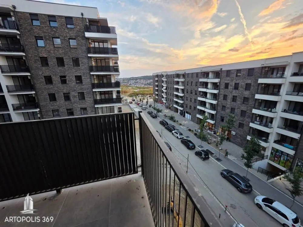 Balcony view of the street and modern residential buildings.
