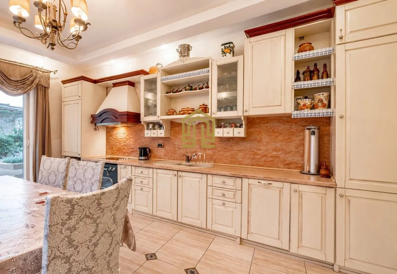 Spacious kitchen with light-colored cabinets and a dining table.
