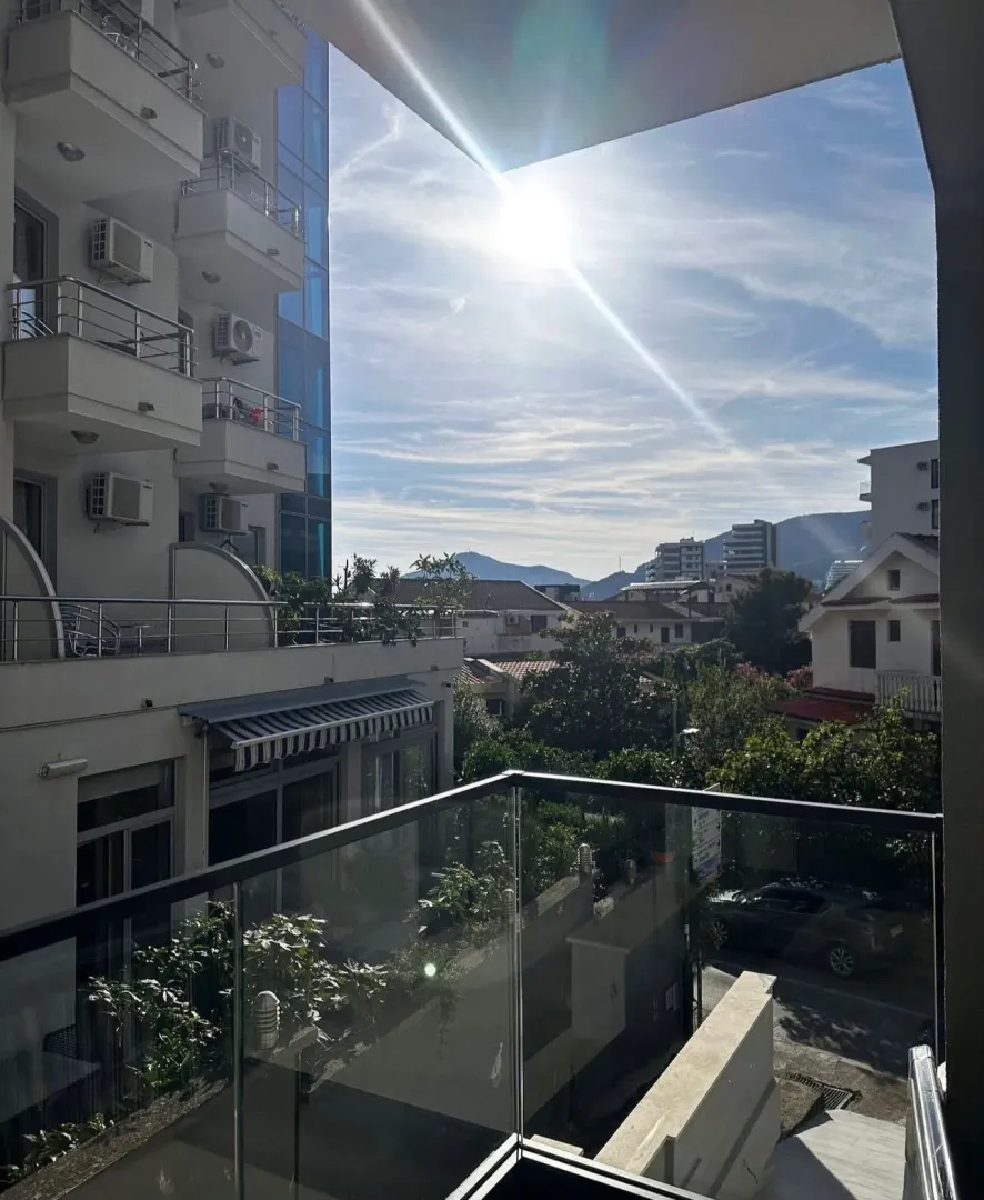 Pogled sa terase na okolne zgrade i planine.