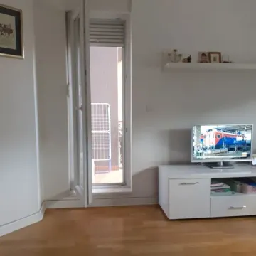 Living room with a white chest of drawers, TV, and a view through the window. - image 7