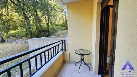 Natkriveni balkonski prostor sa malim stolom i pogledom na zelenilo. - image 6