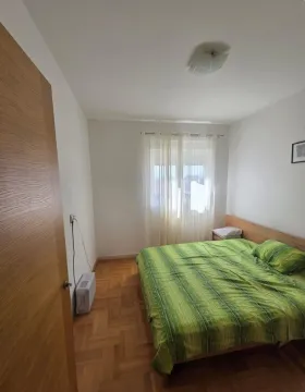 Namještena spavaća soba sa bračnim krevetom, parketom i prozorom. - image 4