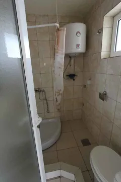 Manje kupatilo sa tuš kabinom, bojlerom i WC šoljom obloženo keramičkim pločicama. - image 8