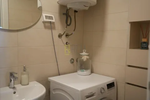 Small bathroom with a sink, washing machine, and wall-mounted water heater. - image 6
