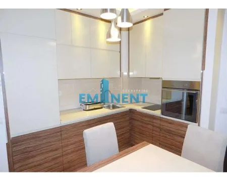 Modern kitchen with built-in appliances and a dining table. - image 8