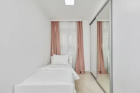 Small bedroom with a bed and a large built-in mirrored wardrobe. - image 11