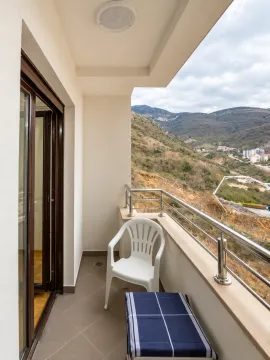 Natkriveni balkon sa staklenom ogradom i pogledom na okolna brda. - image 7