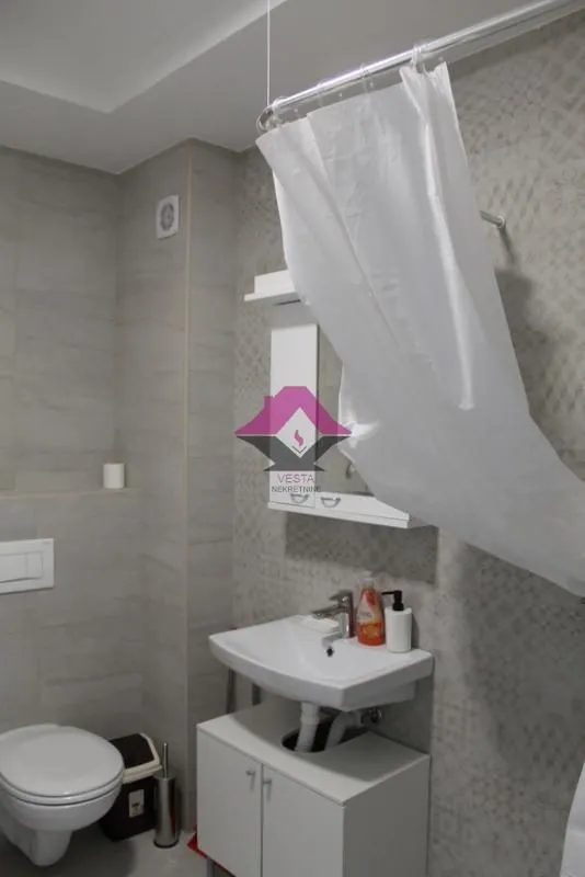 Bathroom equipped with a washbasin, toilet, and shower.