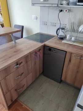Kuhinja sa drvenim elementima, ugradnom pločom i mašinom za sudove. - image 3
