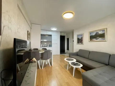 Living room with a sofa, TV, and a dining table in the continuation. - image 9