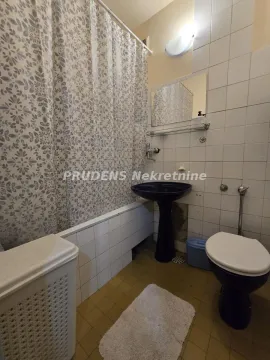 Kupatilo opremljeno kadom, umivaonikom, WC šoljom i pločicama na zidovima. - image 11