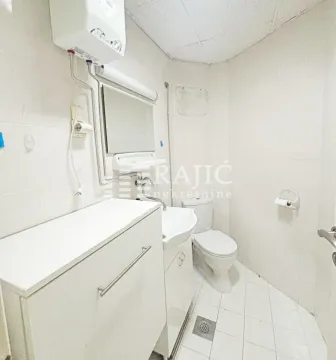 Small bathroom with a sink, mirror, and toilet. - image 9