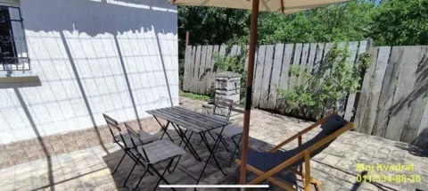 Popločano dvorište sa stolom, stolicama i suncobranom. - image 9