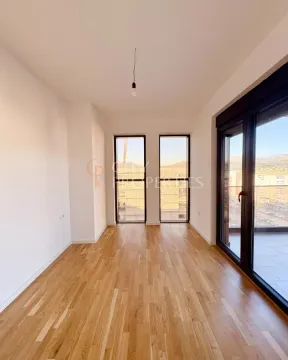 Empty room with wooden flooring and access to the terrace. - image 5