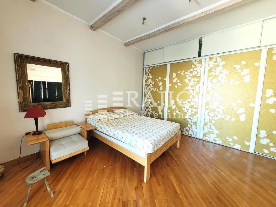 Furnished bedroom with a wooden bed and built-in wardrobe.