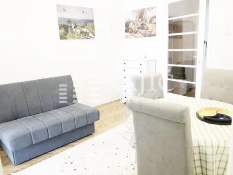 Living room with a sofa and a dining table. - image 5