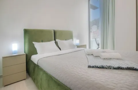 Modern bedroom with a large double bed and nightstands. - image 7