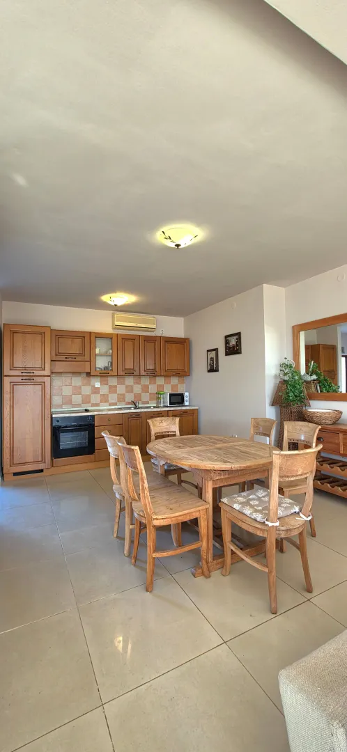 Spacious kitchen with wooden cabinets and a dining table.