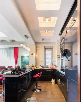 Moderna kuhinja sa šankom i ugradnim elementima u tamnim tonovima. - image 9
