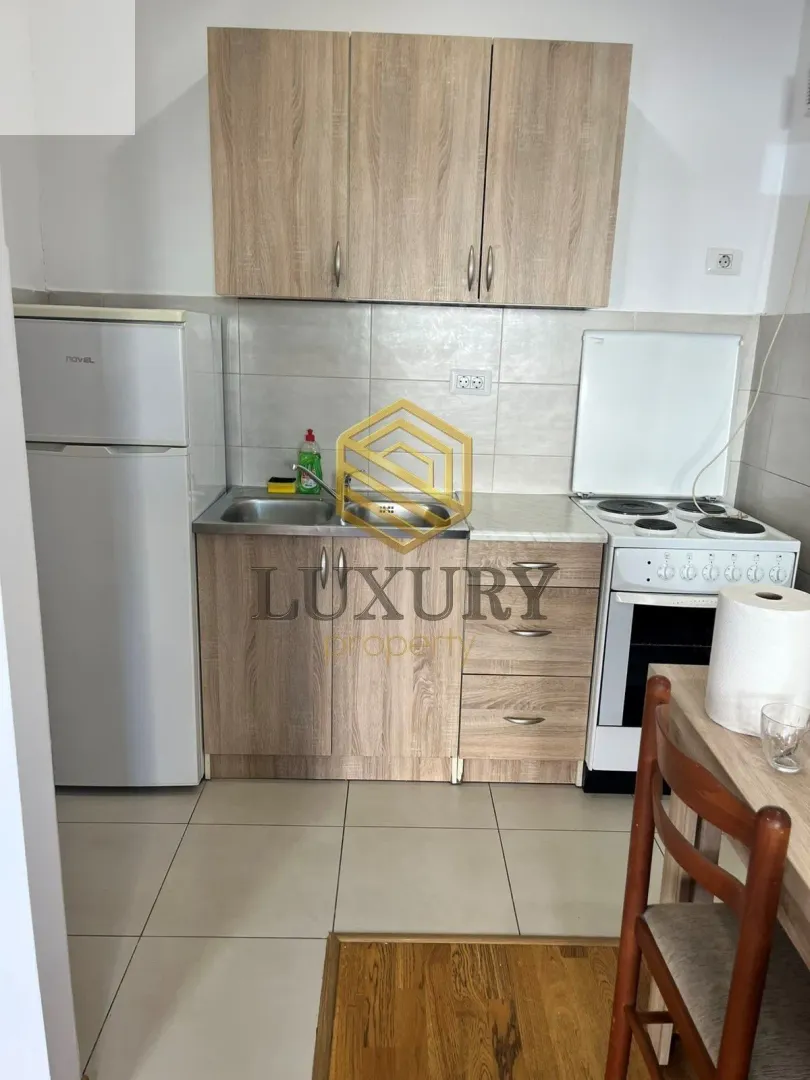 Small kitchen with wood-tone cabinets, refrigerator, and stove.