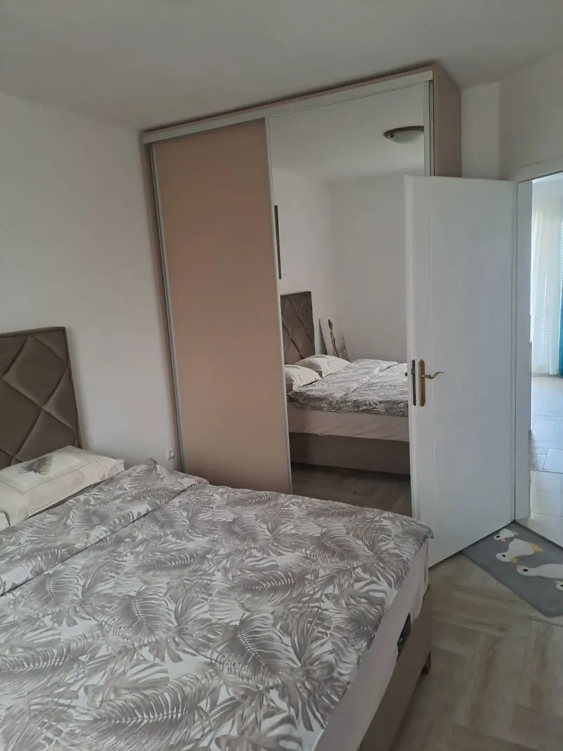 Bedroom with a double bed and a large built-in wardrobe with a mirror.