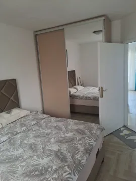 Bedroom with a double bed and a large built-in wardrobe with a mirror. - image 4