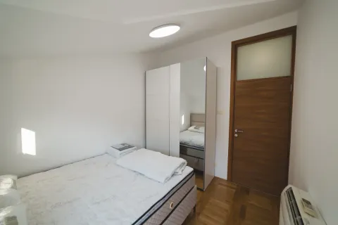 Small bedroom with a bed, wardrobe, and wooden door. - image 8