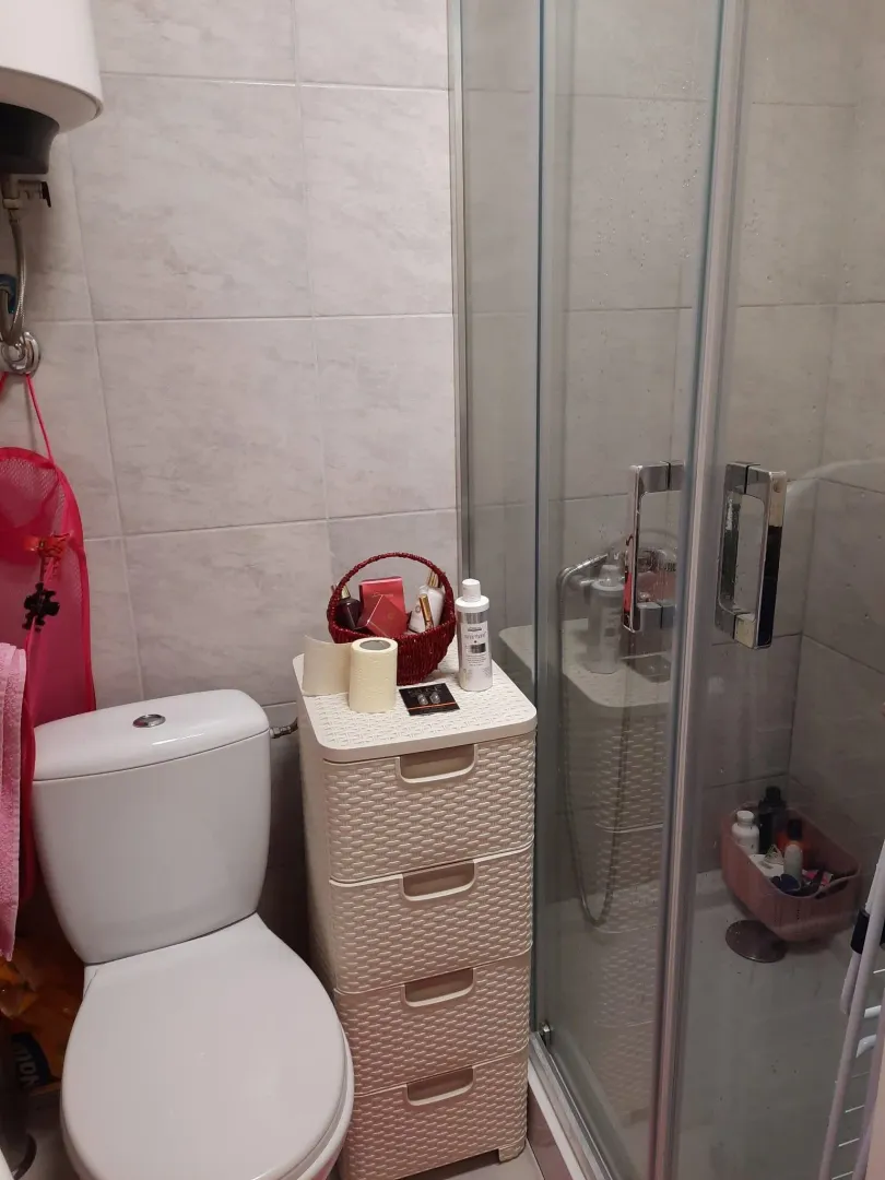Kompaktno kupatilo sa wc šoljom, plastičnom komodom i tuš kabinom.